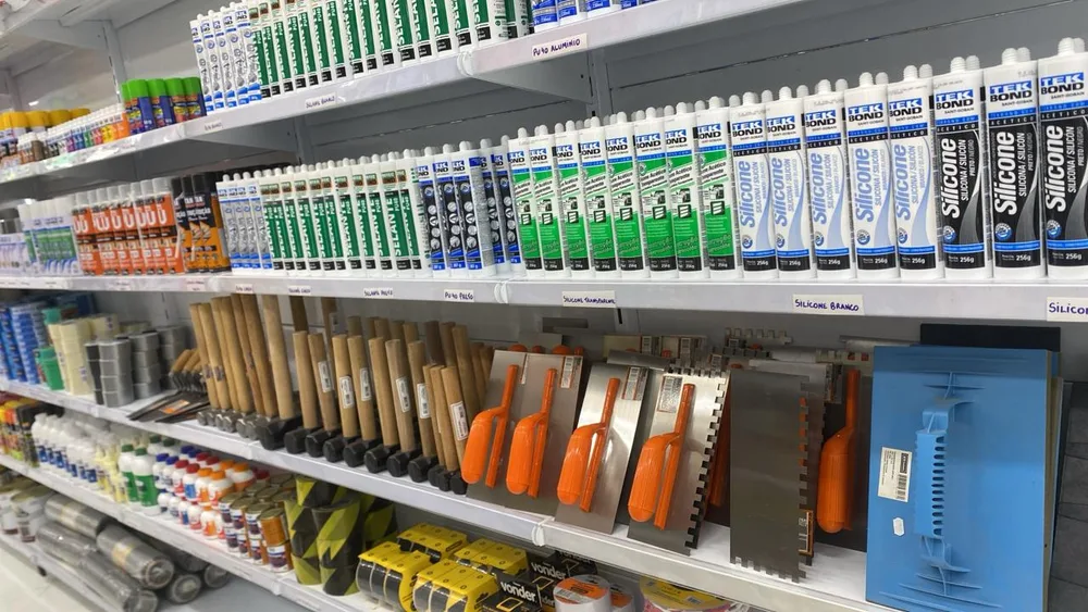 Prateleira com silicones, selantes e ferramentas para acabamento na Jhow Mais